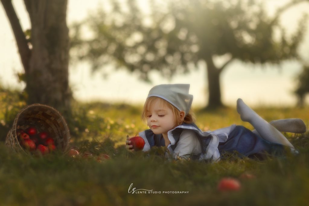 Outdoor fine art photo session of girl in apple orchard