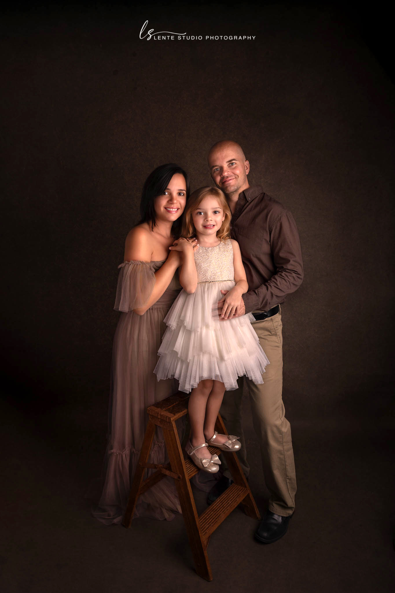 family of 3 posing for a stunning studio Portrait